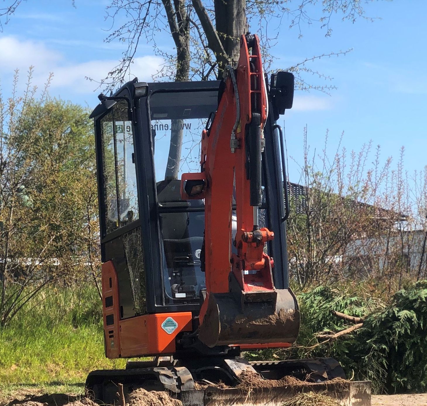 Ein roter Bagger buddelt ein Loch