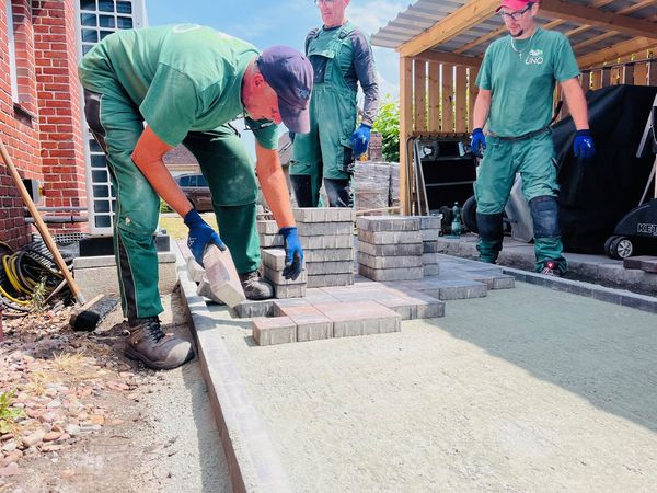 Mitarbeiter pflastern eine Terasse
