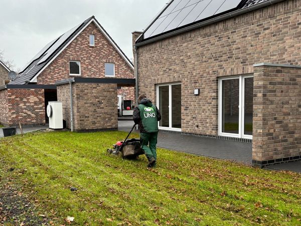 Ein Mitarbeiter mäht den Rasen