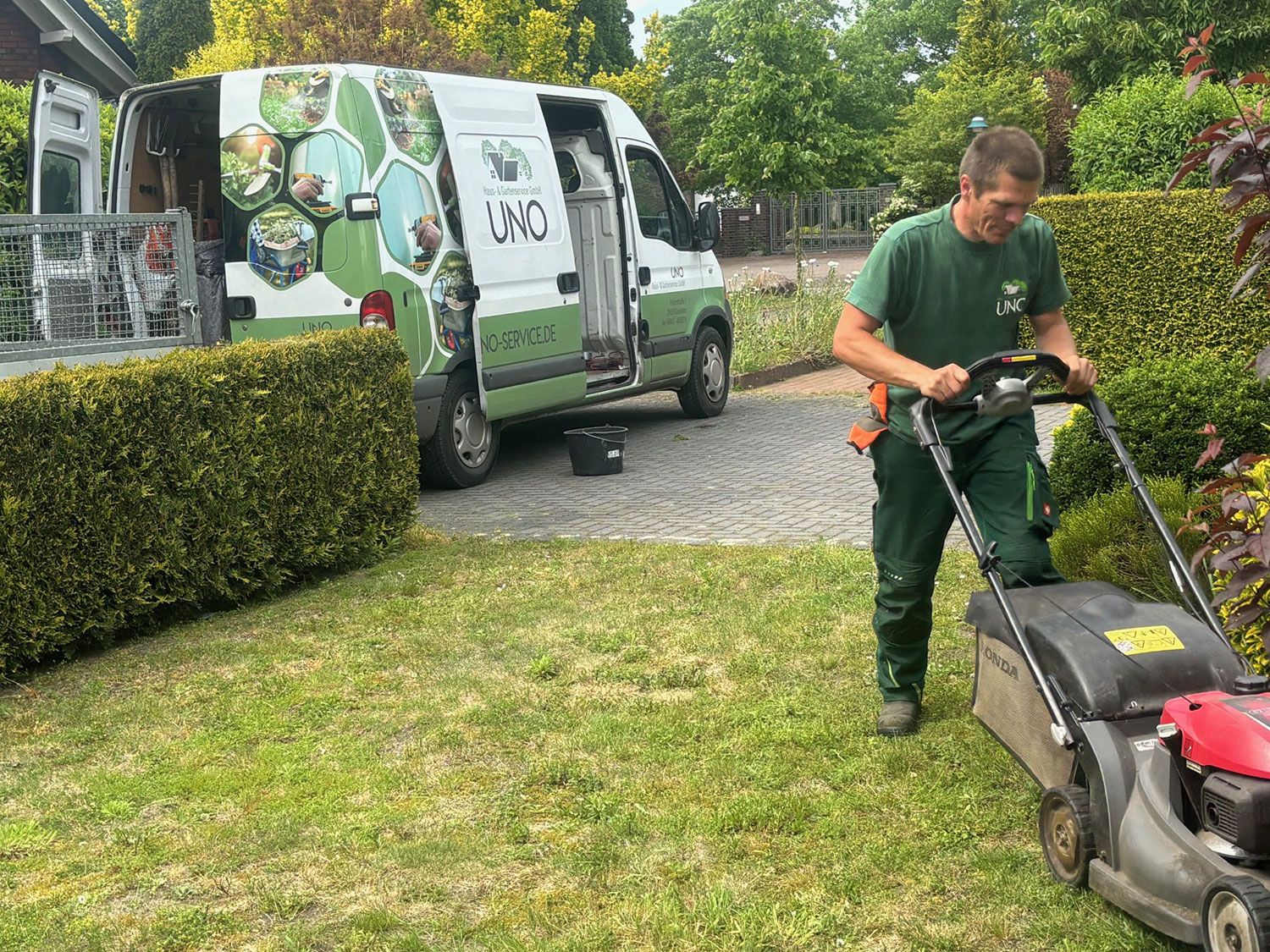 Ein Mitarbeiter mäht den Rasen