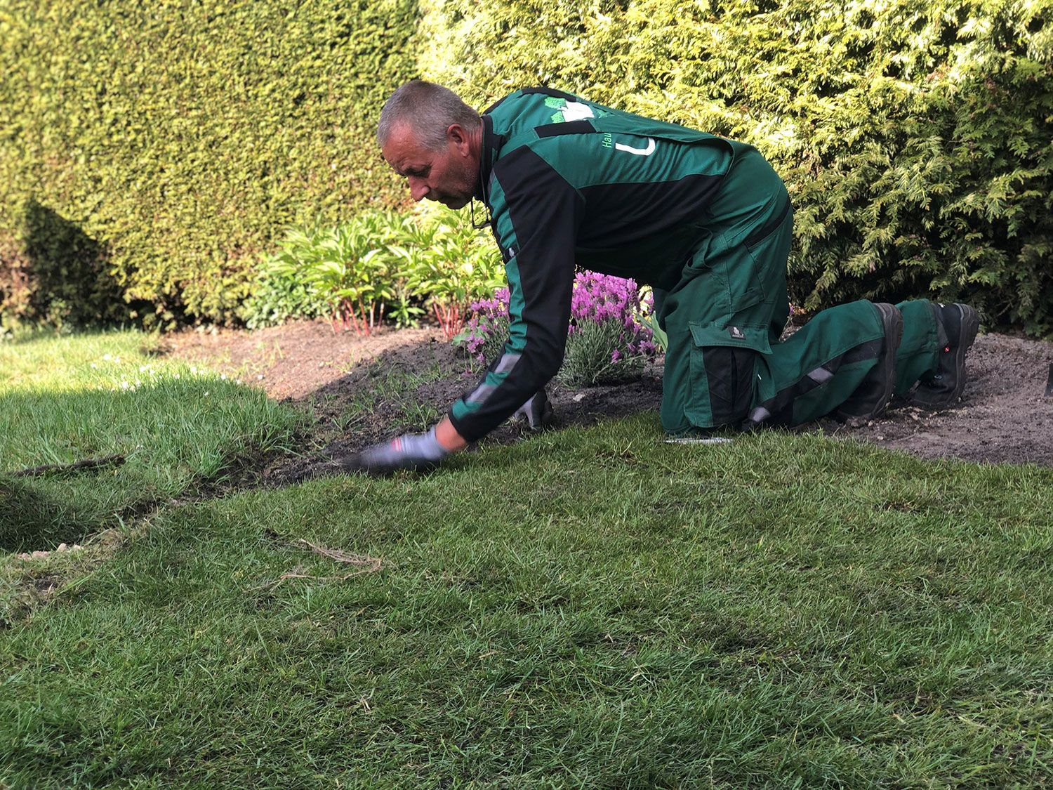 Ein Mitarbeiter pflegt den Rasen