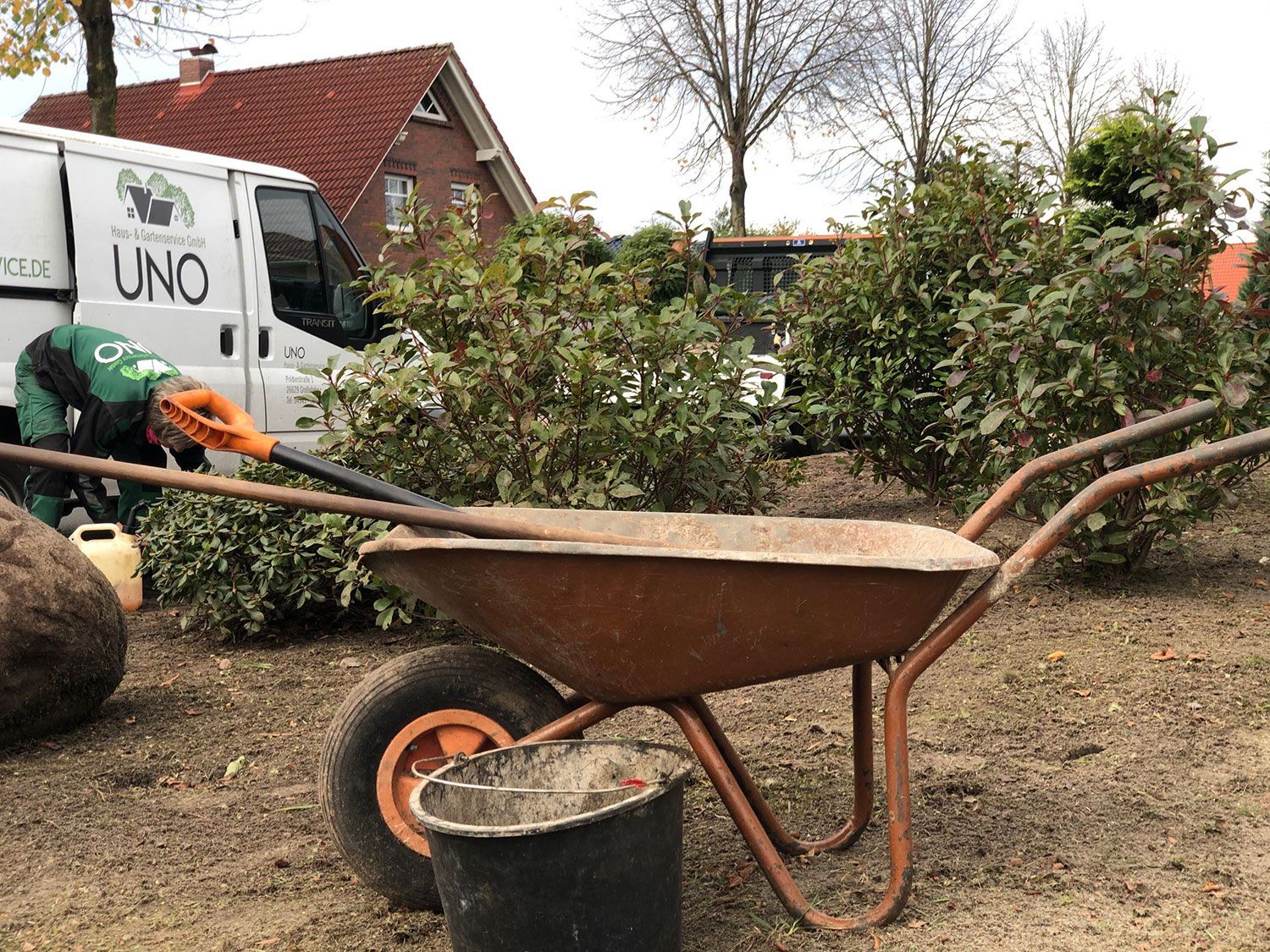 Eine Schubkarre mit einem Mitarbeiter im Hintergrund