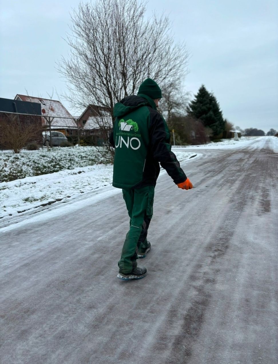 Ein Mitarbeiter läuft auf einer vereisten Straße